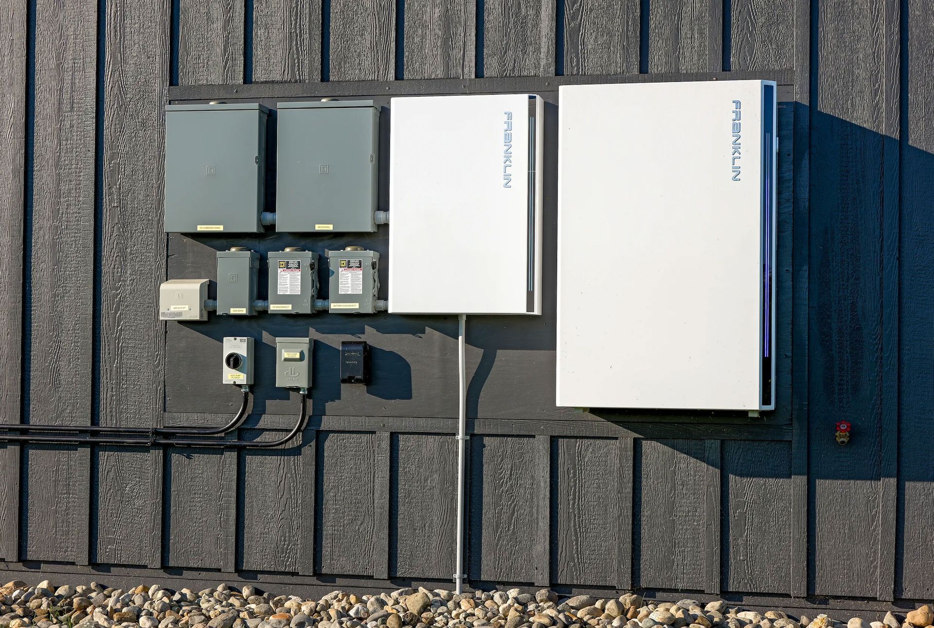 Electrical equipment boxes mounted on a rooftop beside a large white unit