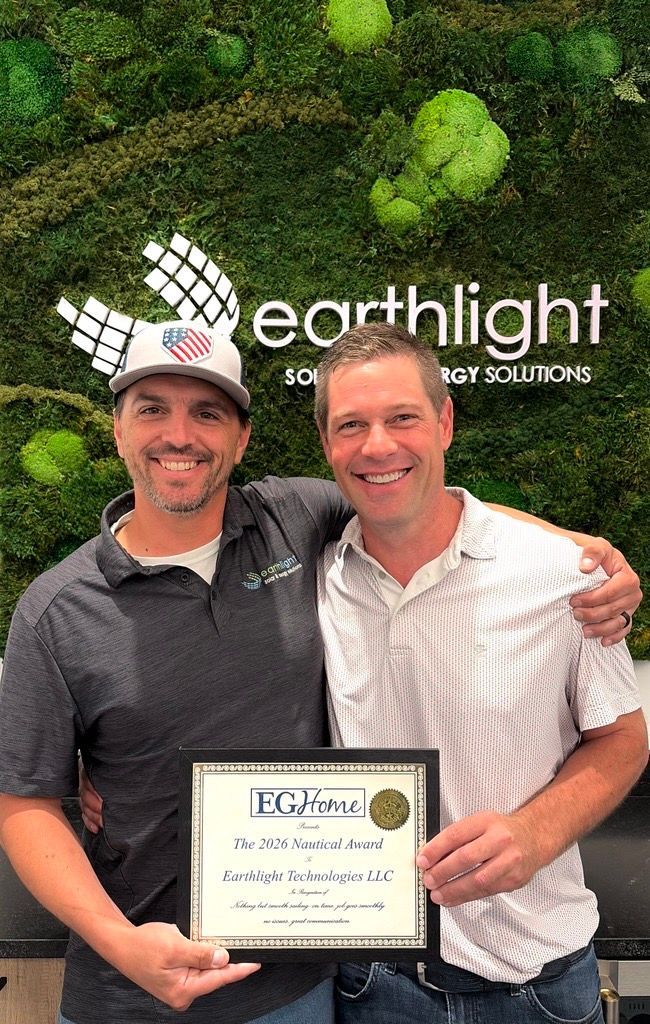 Two smiling men hold a framed certificate in front of an Earthlight wall