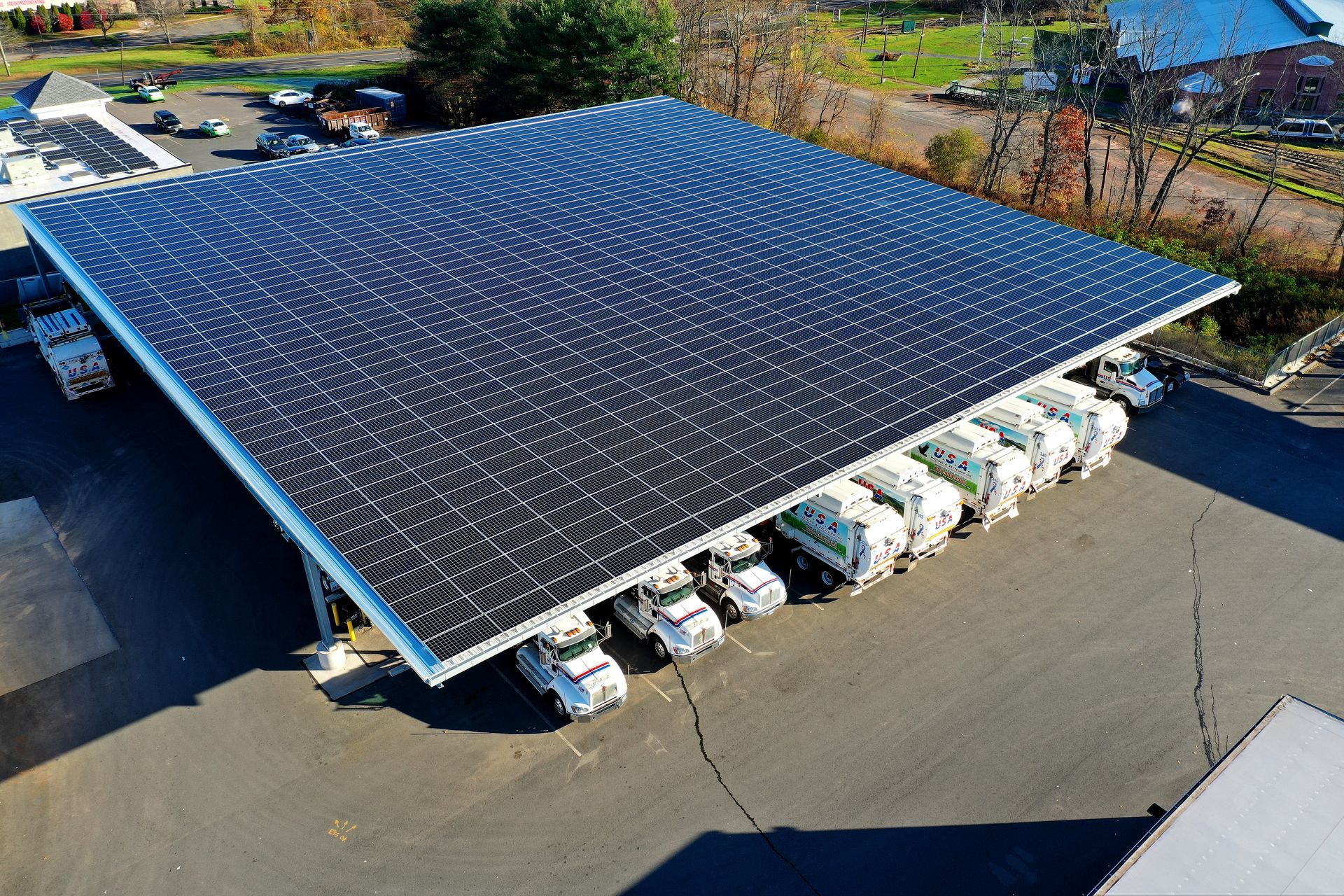 Solar-panel-covered parking canopy with cars parked underneath on a sunny lot