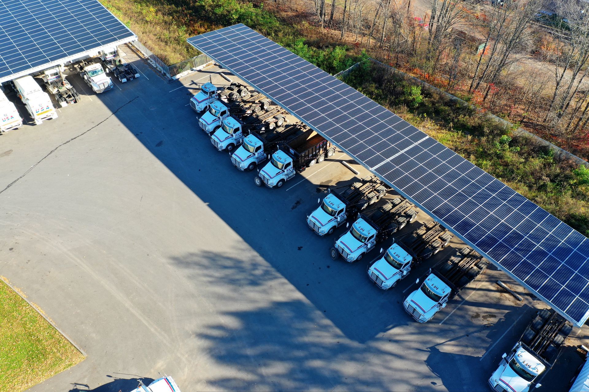 Aerial view of blue cars parked beside solar panels in a lot