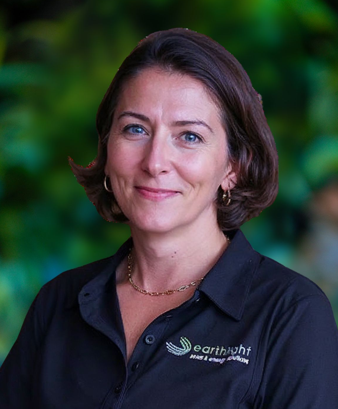 Portrait of a smiling person in a black branded polo against a blurred green background