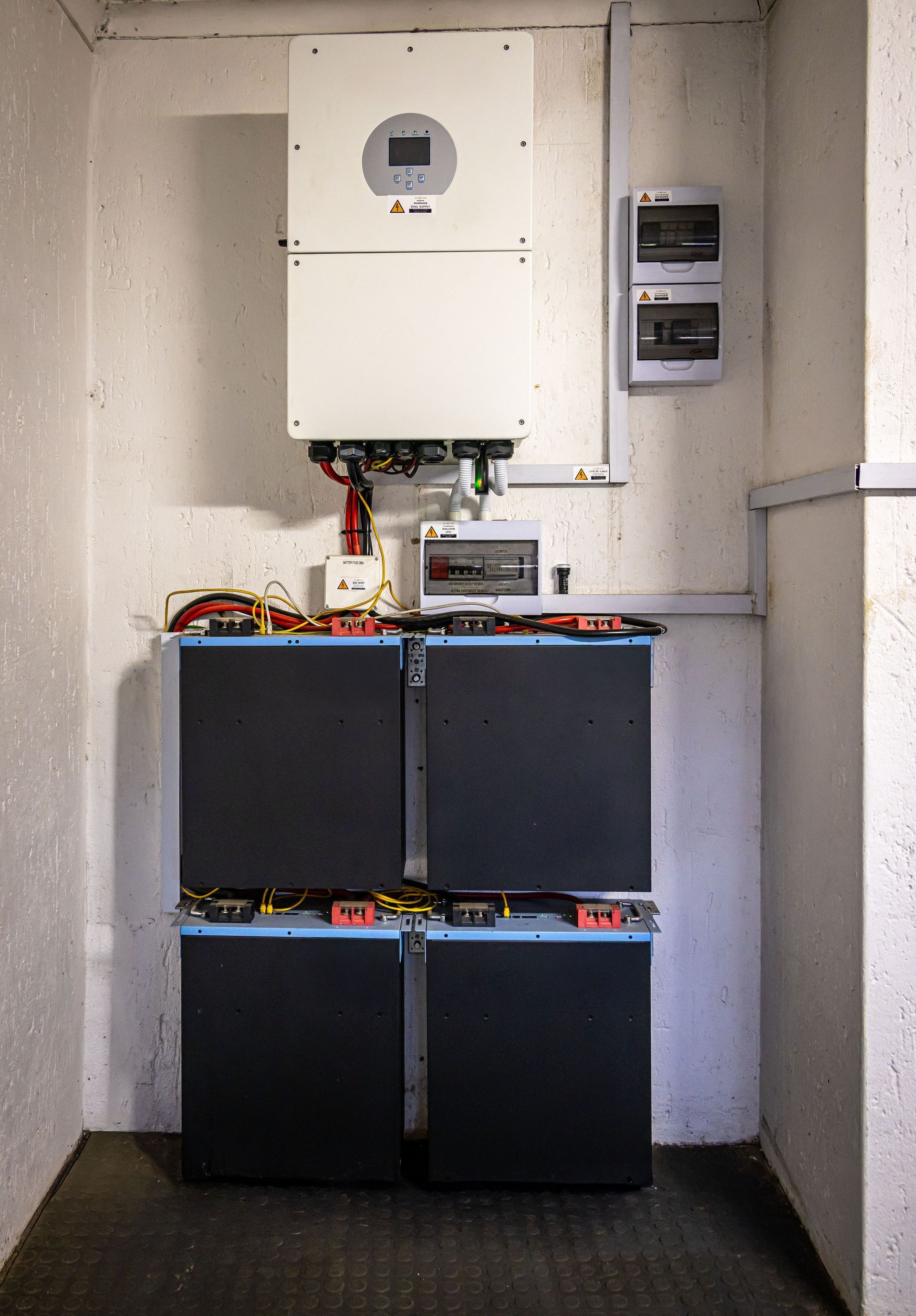 Wall-mounted electrical equipment and batteries in a narrow utility alcove