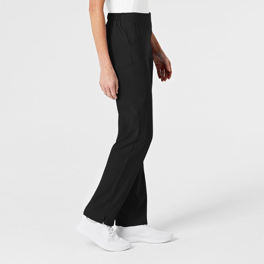 Woman in black pants and white shoes, standing on a white background.