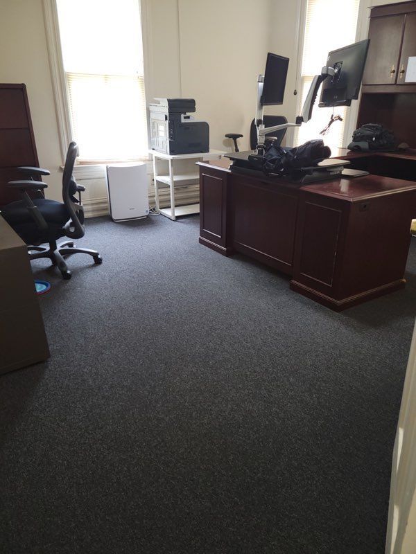 An office with a desk and chairs and a printer