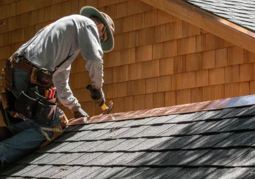 A man is working on the roof of a house.