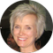 A woman with short blonde hair is smiling in a circle.