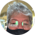 A man wearing glasses and a mask is in a circle.
