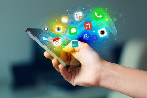 hand holding cell phone with colorful icons