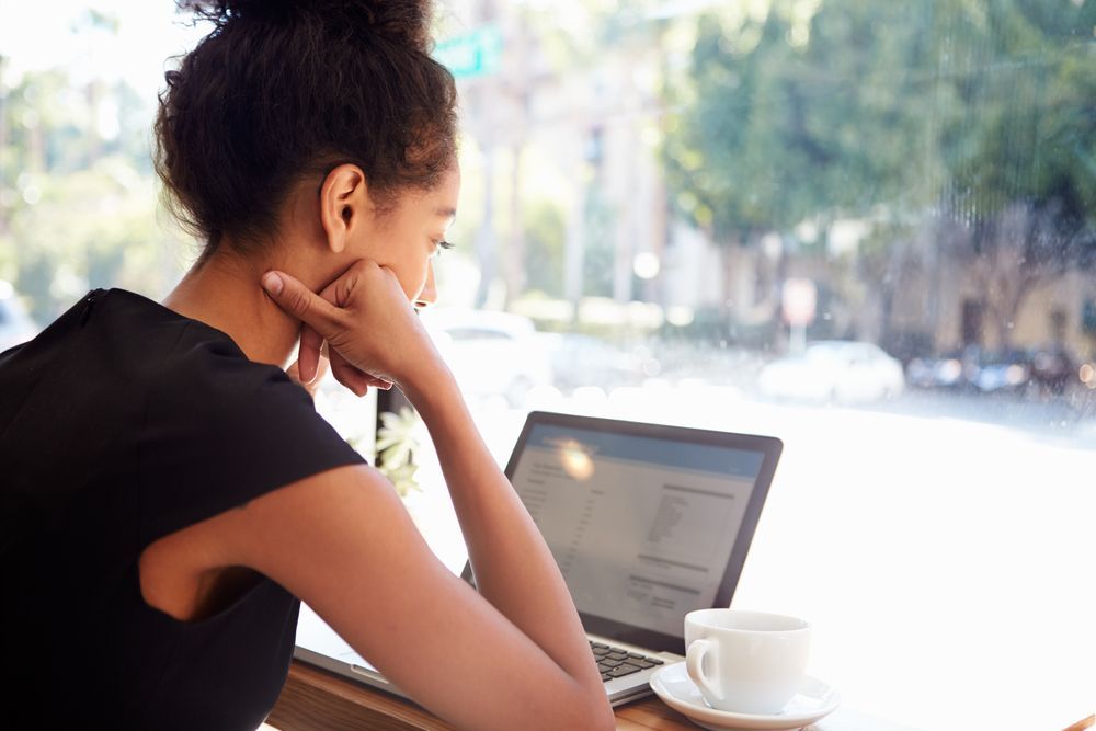 woman working on laptop with cup of tea