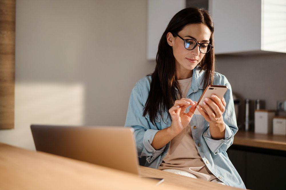 woman working on smart phone and laptop