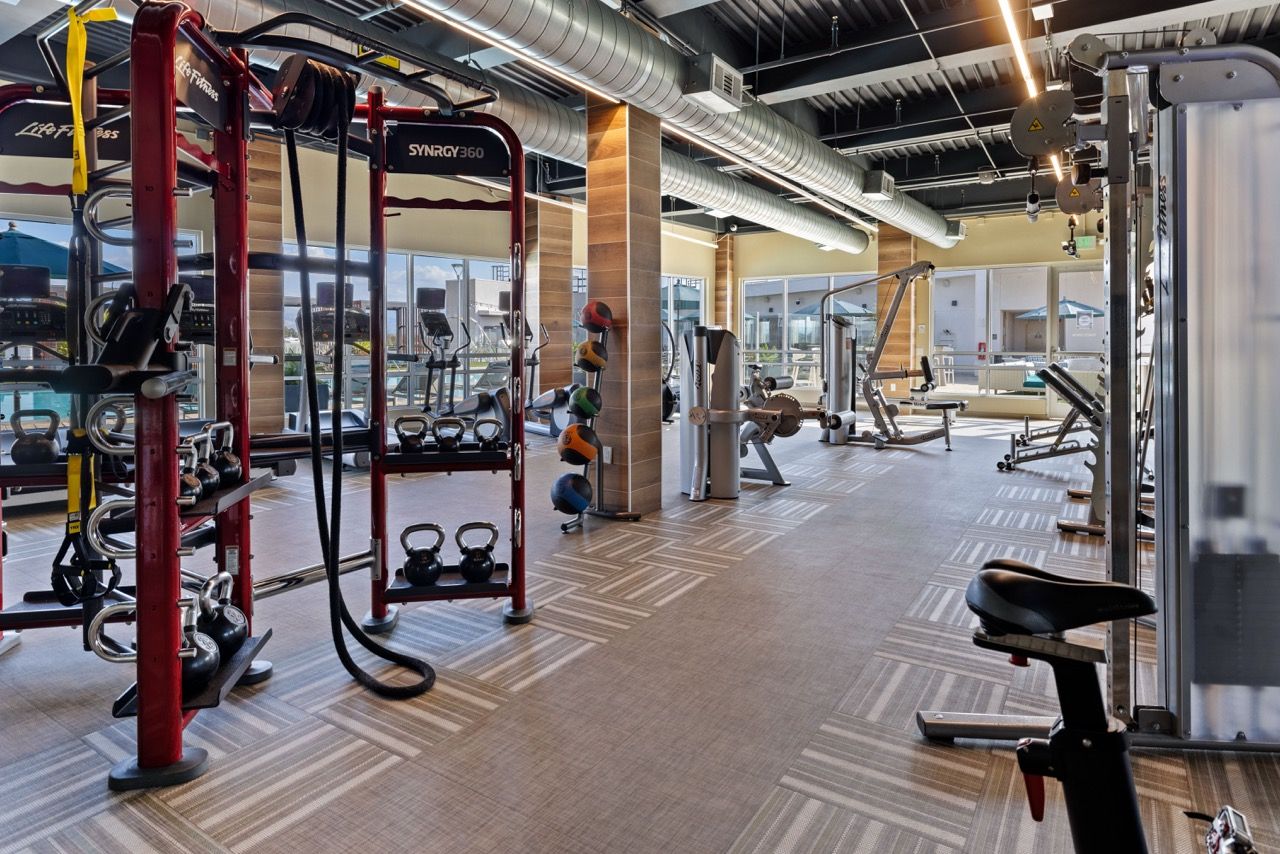 On-site fitness center with weight racks, machines, and cardio area.