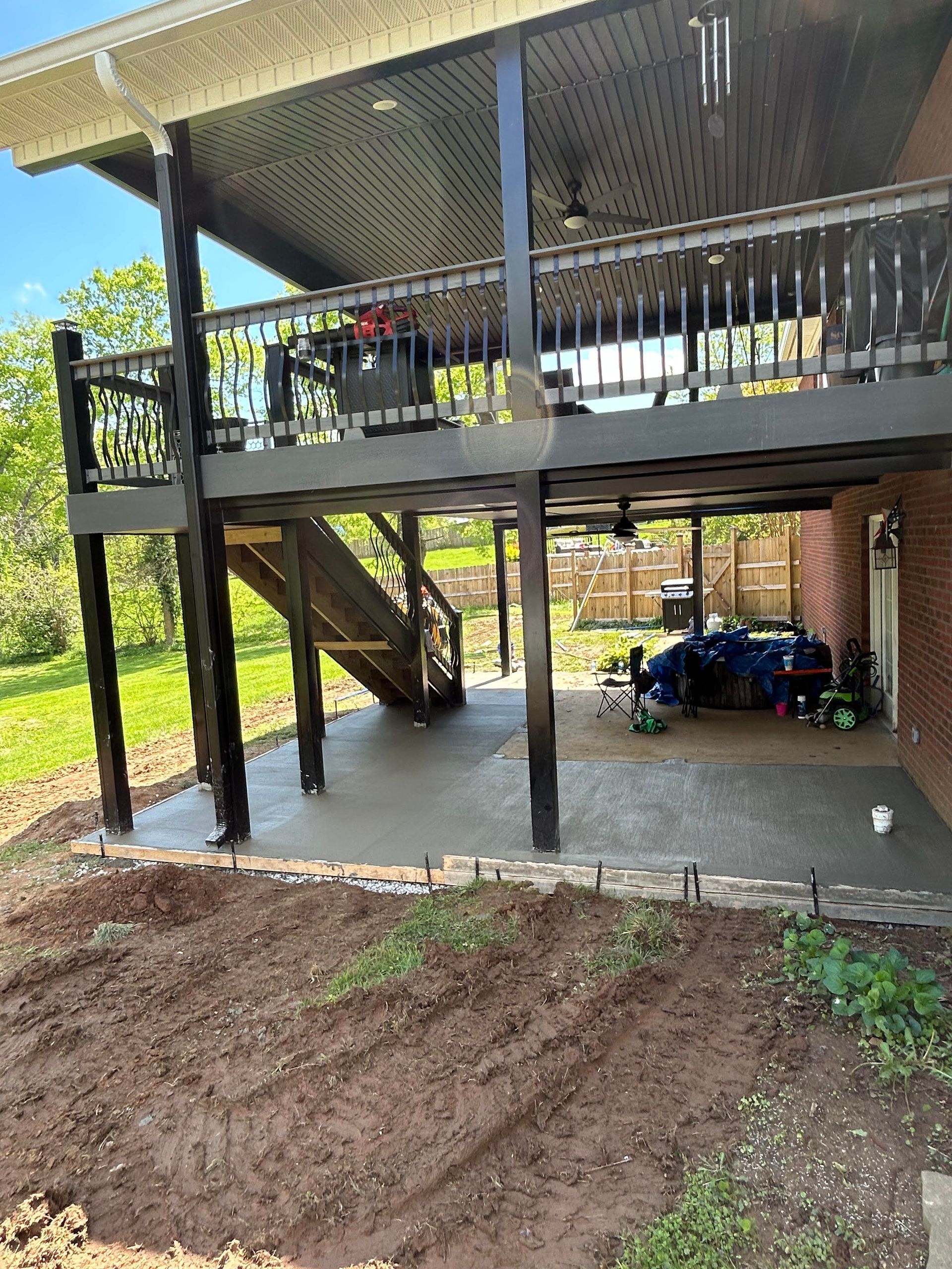 Custom concrete patio addition beneath a existing deck, creating a functional outdoor living space in Bardstown KY 
