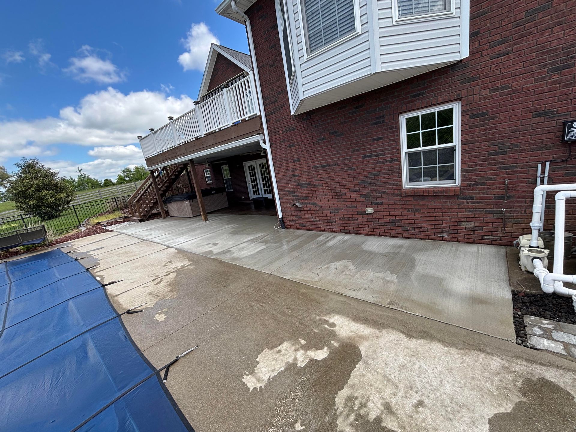 Completed concrete patio extension beside a swimming pool, providing additional outdoor space in Glendale, KY