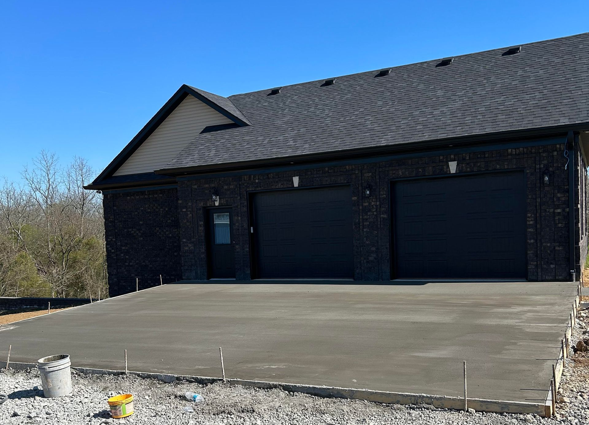New concrete driveway installation with a broom finished surface by Right At Home Construction LLC