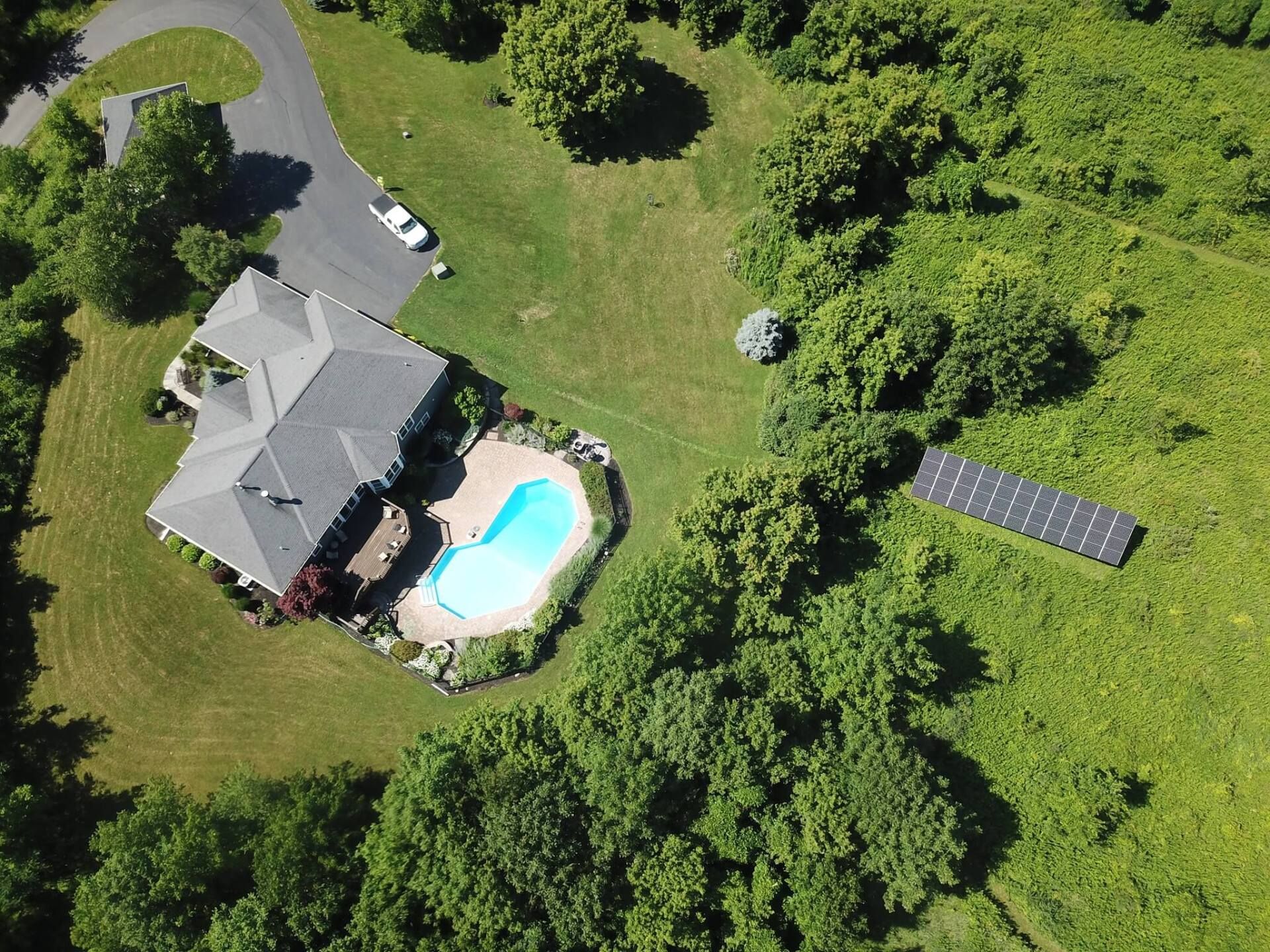 An aerial view of a house with a pool and solar panels