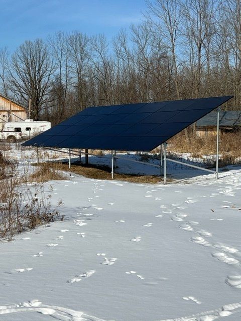 a solar panel is sitting in the middle of a snowy field .