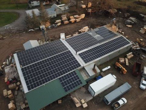 an aerial view of a building with solar panels on the roof .