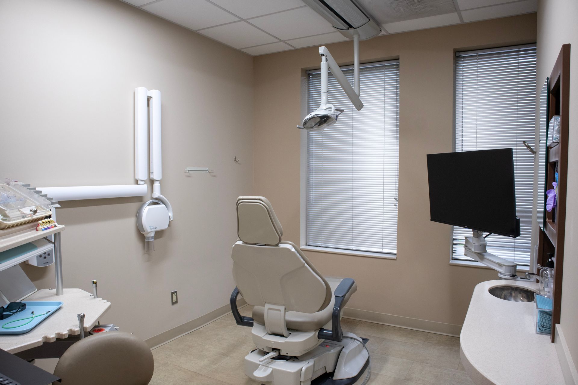 Man flossing teeth in front of a mirror, smiling. He is wearing a white shirt and is in a bathroom.