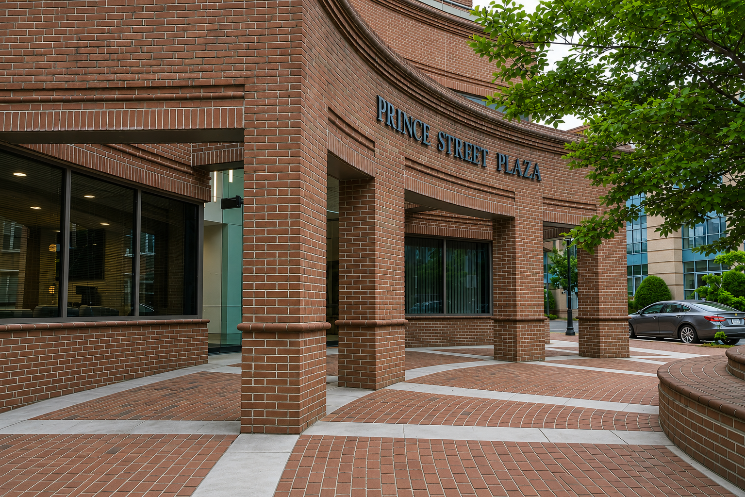 Prince Street Plaza brick building entrance with glass doors, sunny day.