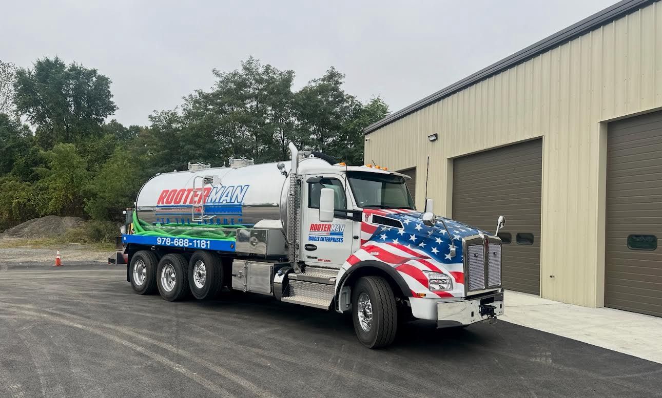 White tanker truck with red and blue patriotic graphics parked outside a warehouse