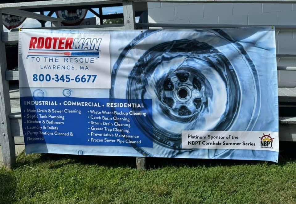 Rotter Man banner with large tire graphic and service list, hanging outdoors on a fence