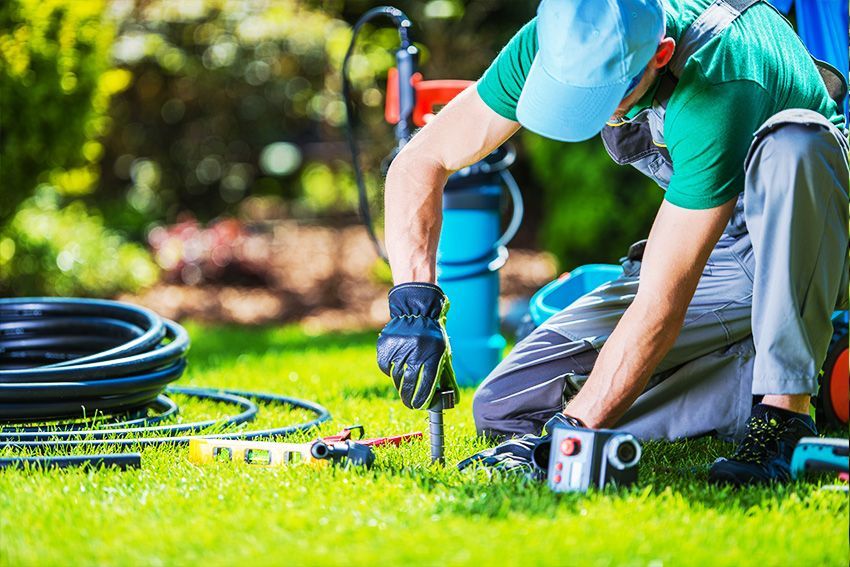 Man Repairing The Sprinkler System — Columbus, NJ — G & G Landscaping Construction, Inc. Man Repairing The Sprinkler System — Columbus, NJ — G & G Landscaping Construction, Inc.