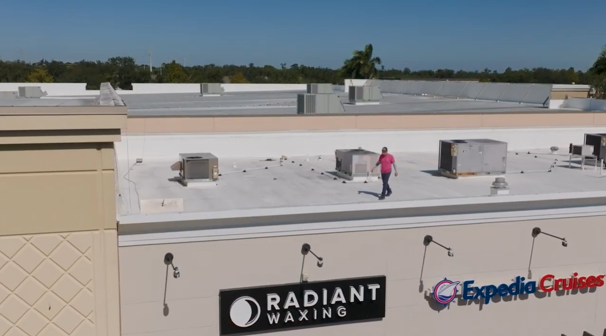 Rooftop HVAC units above storefronts, including Radiant Waxing and Expedia Cruises signs.