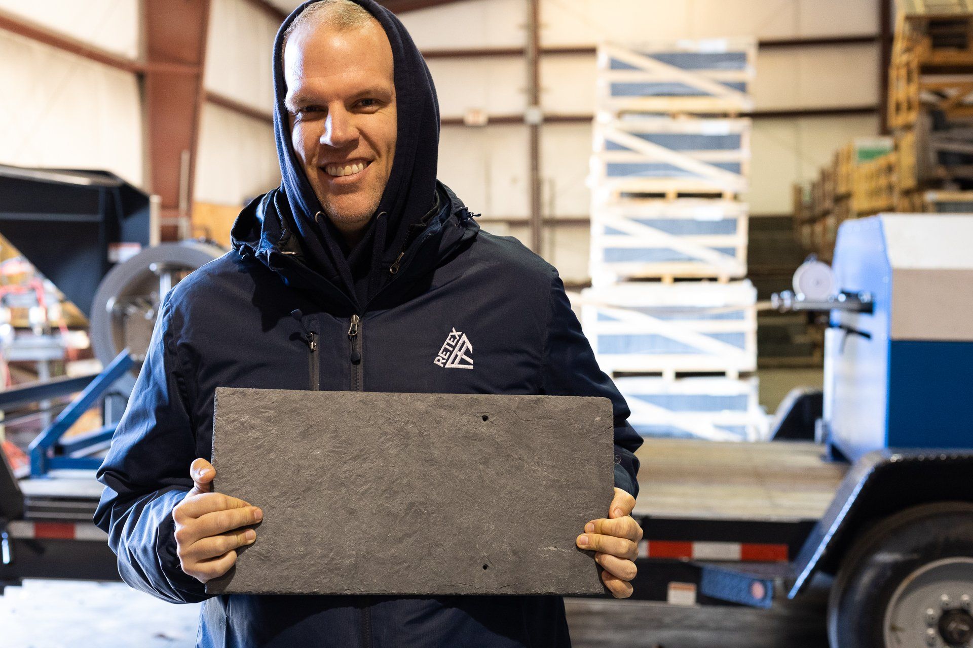 An image of RETEX's Mark Erickson holding up a piece of natural slate during a team training event.