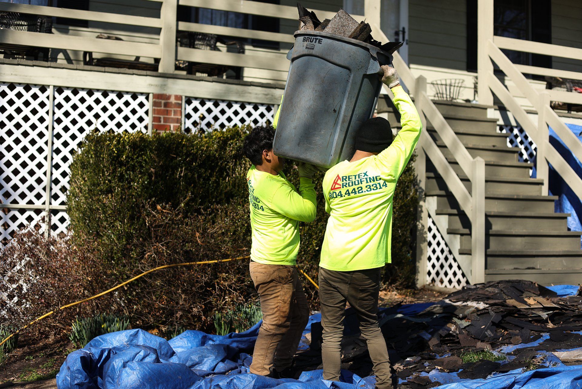 Image of RETEX workers cleaning up roof debris outside home in North Chesterfield VA 23235. Photo by RETEX's Katelyn Lewis.
