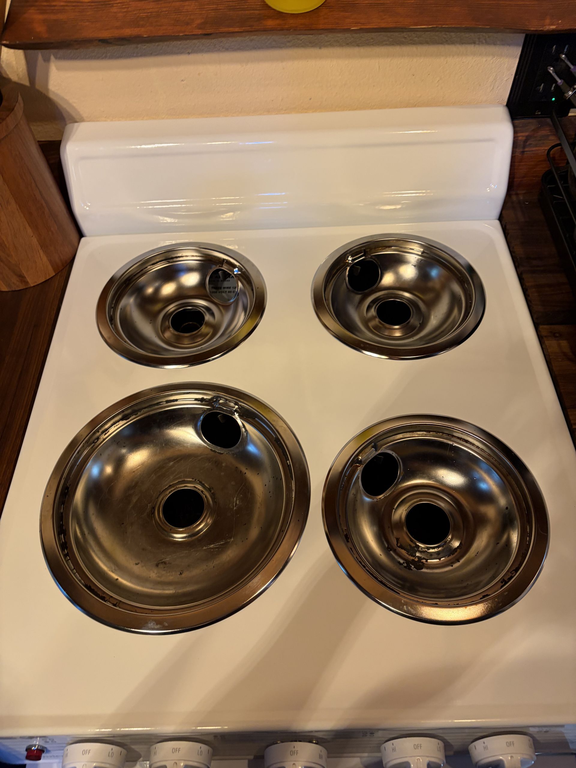 Four stainless steel bowls on a white stove or countertop, arranged in a square.