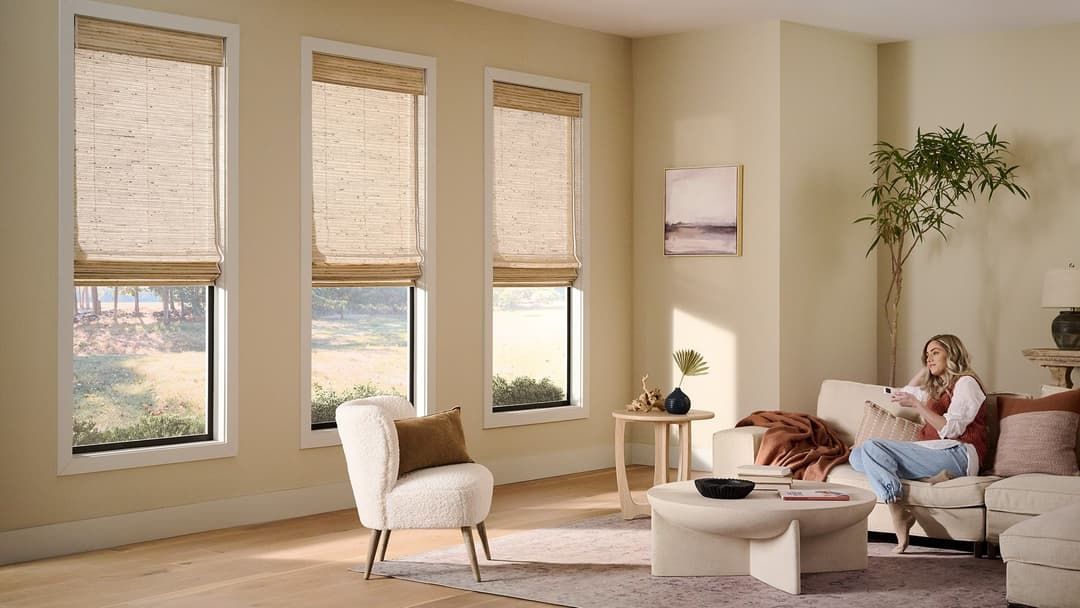 Alta Motorized Woven Wood, woman operating shades with remote control.