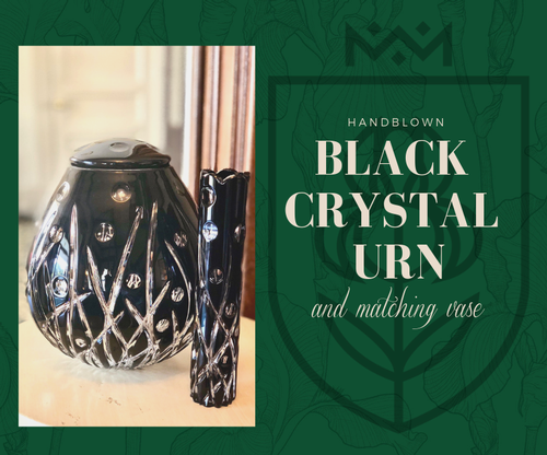 Black crystal urn with matching vase on green background, labeled handblown black crystal urn