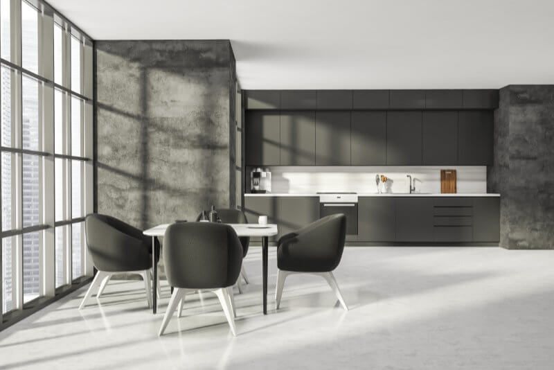 A kitchen with a table and chairs in front of a large window.