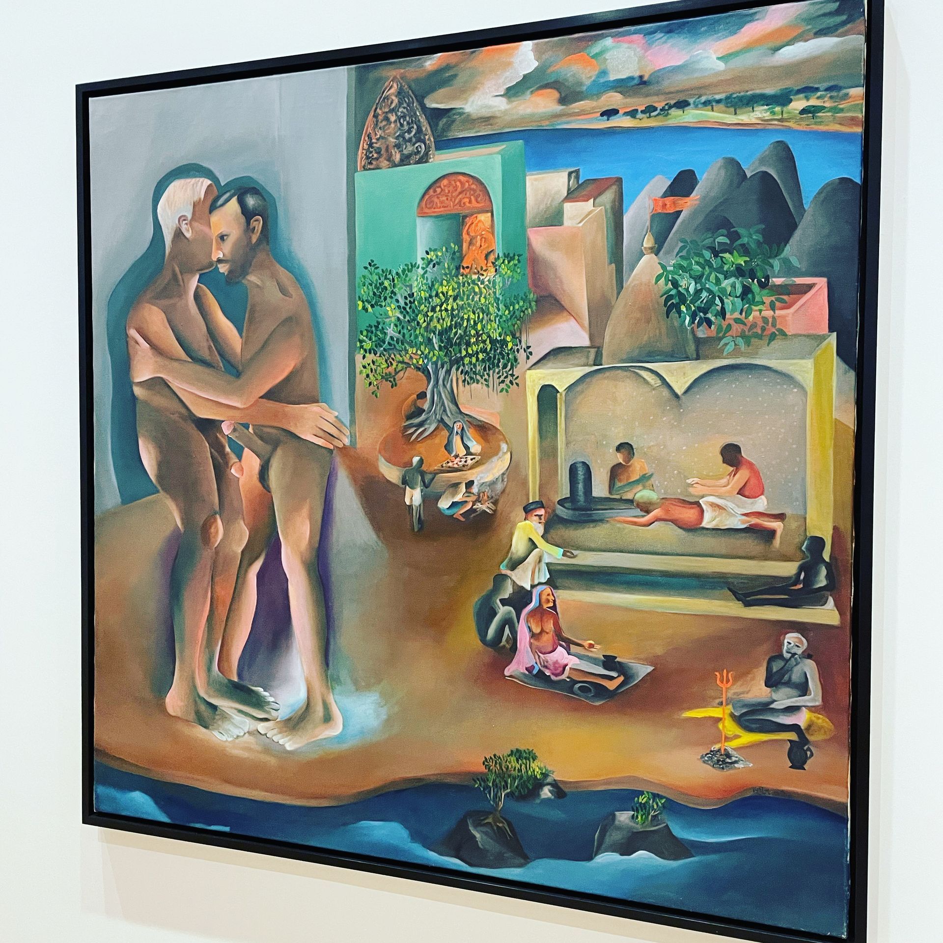 Painting of two figures embracing, with an outdoor scene featuring figures near water and buildings, framed.