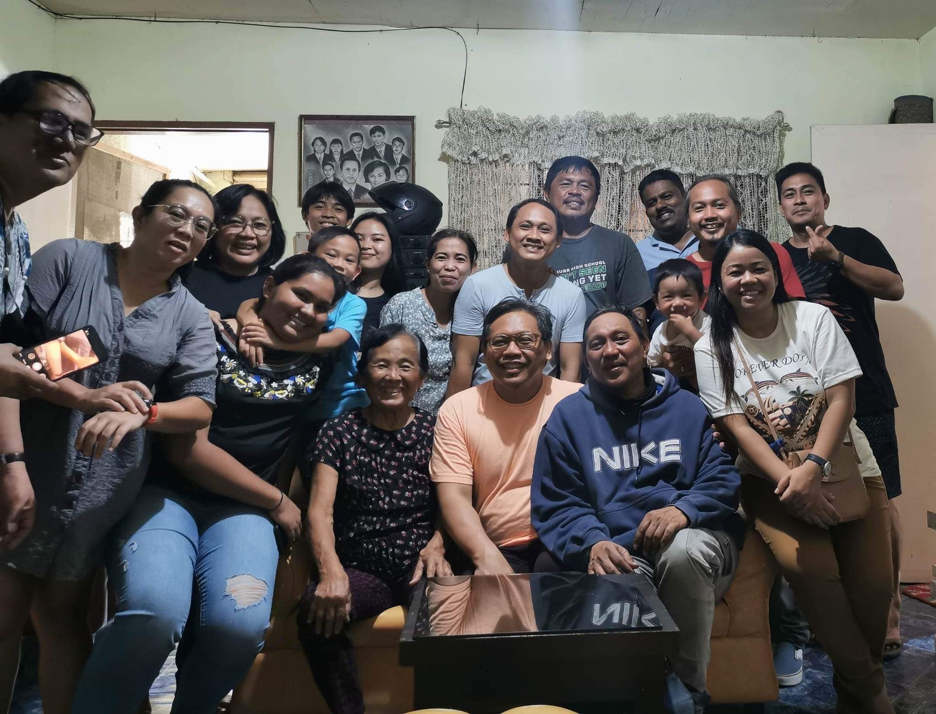 Group of people smiling, posing for a photo indoors, neutral expressions.