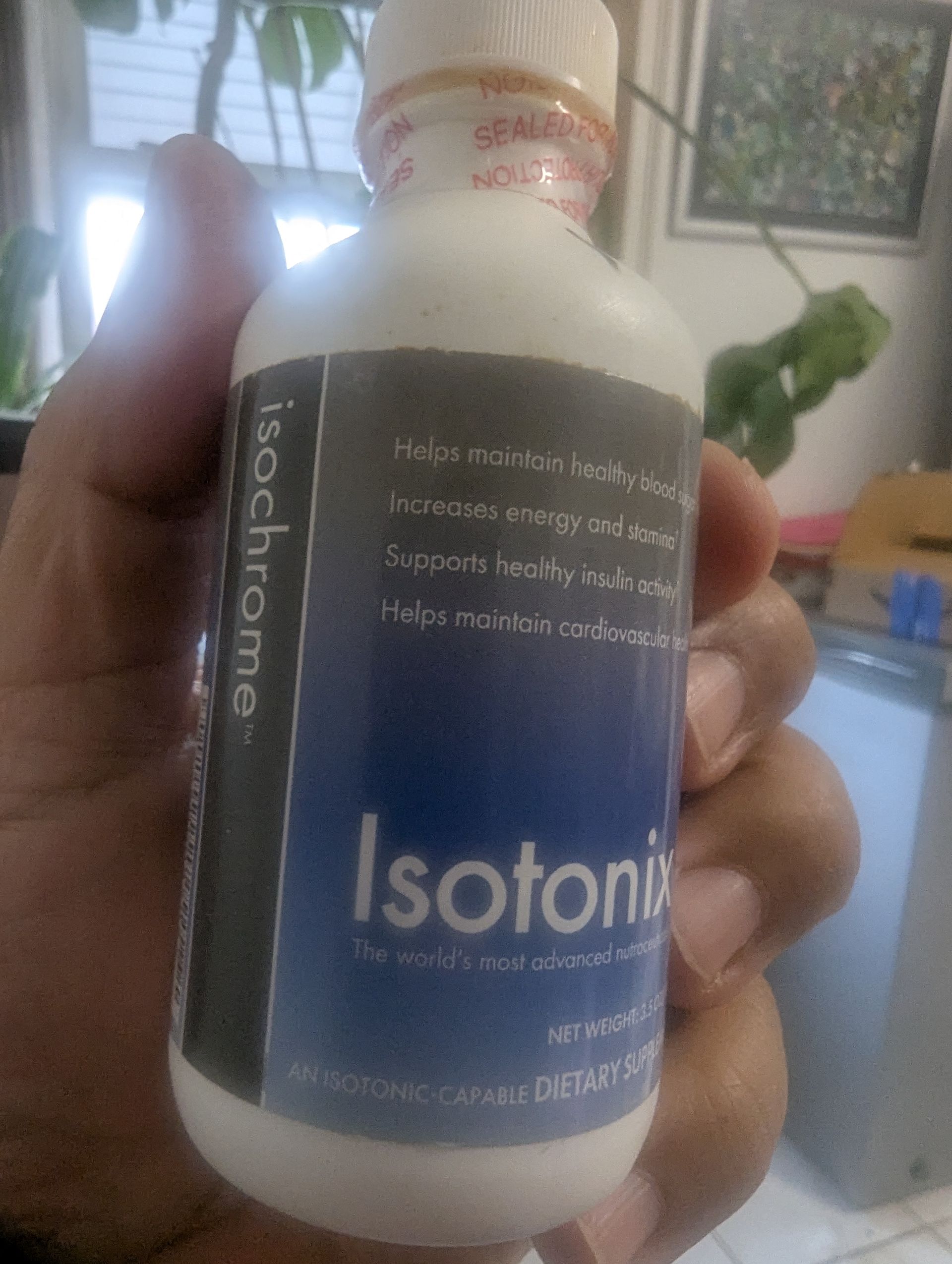 Hand holding a white bottle labeled 