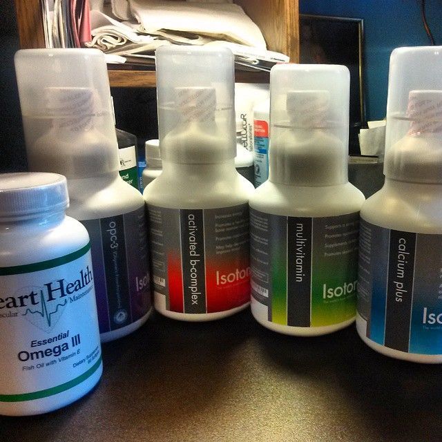 Bottles of dietary supplements: Omega, Isotonix, Activated B-Complex, Multivitamin, and Calcium.