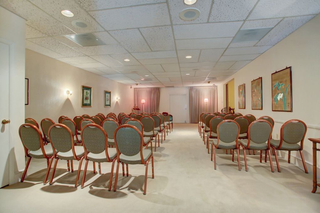 A large room with rows of chairs and tables