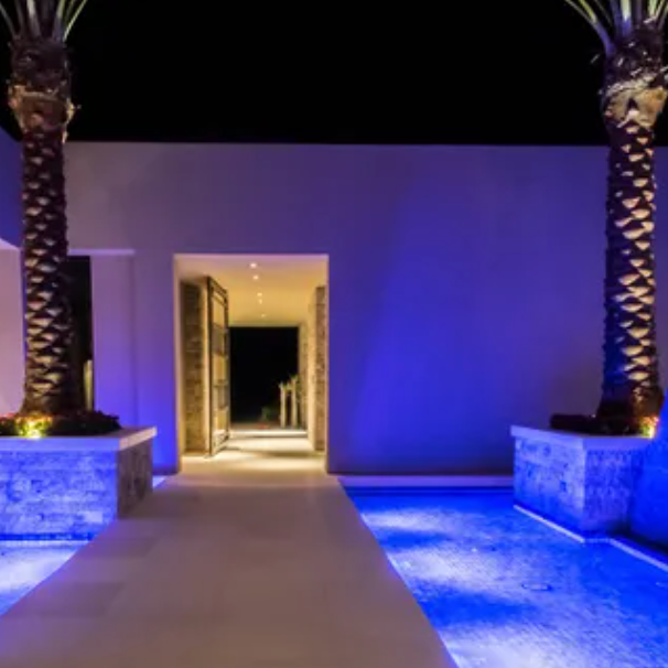 A walkway leading to a swimming pool with blue lights