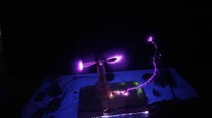 A person is standing in a dark room with purple lights.