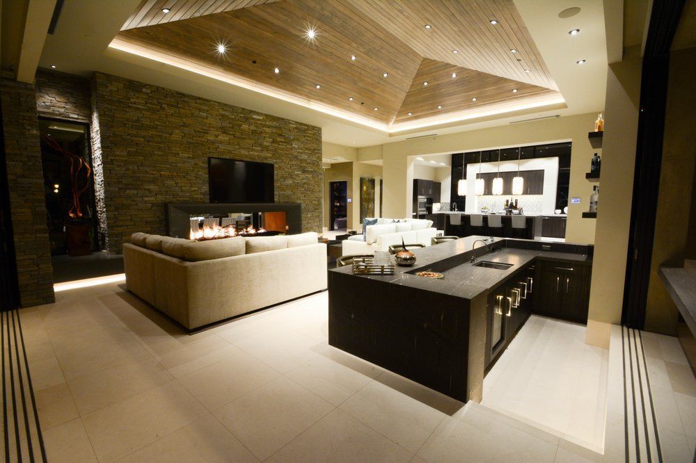 A living room with a couch and a fireplace and a kitchen