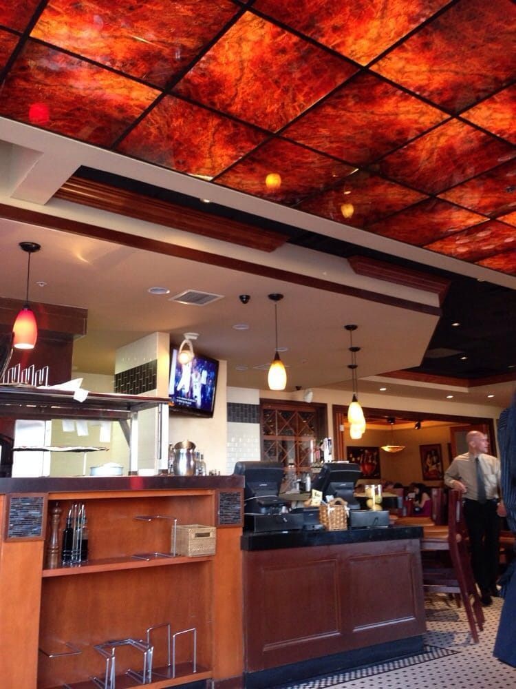The inside of a restaurant with a red ceiling
