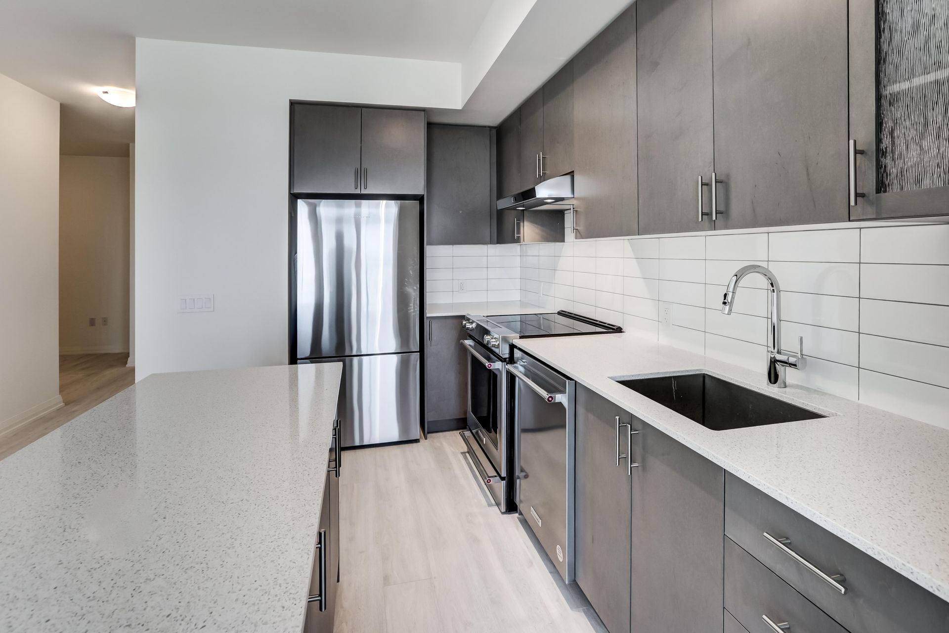 Modern kitchen with stainless steel appliances, grey cabinets, and white countertops — Fast Tech Appliance Repairs in Belmont, NSW