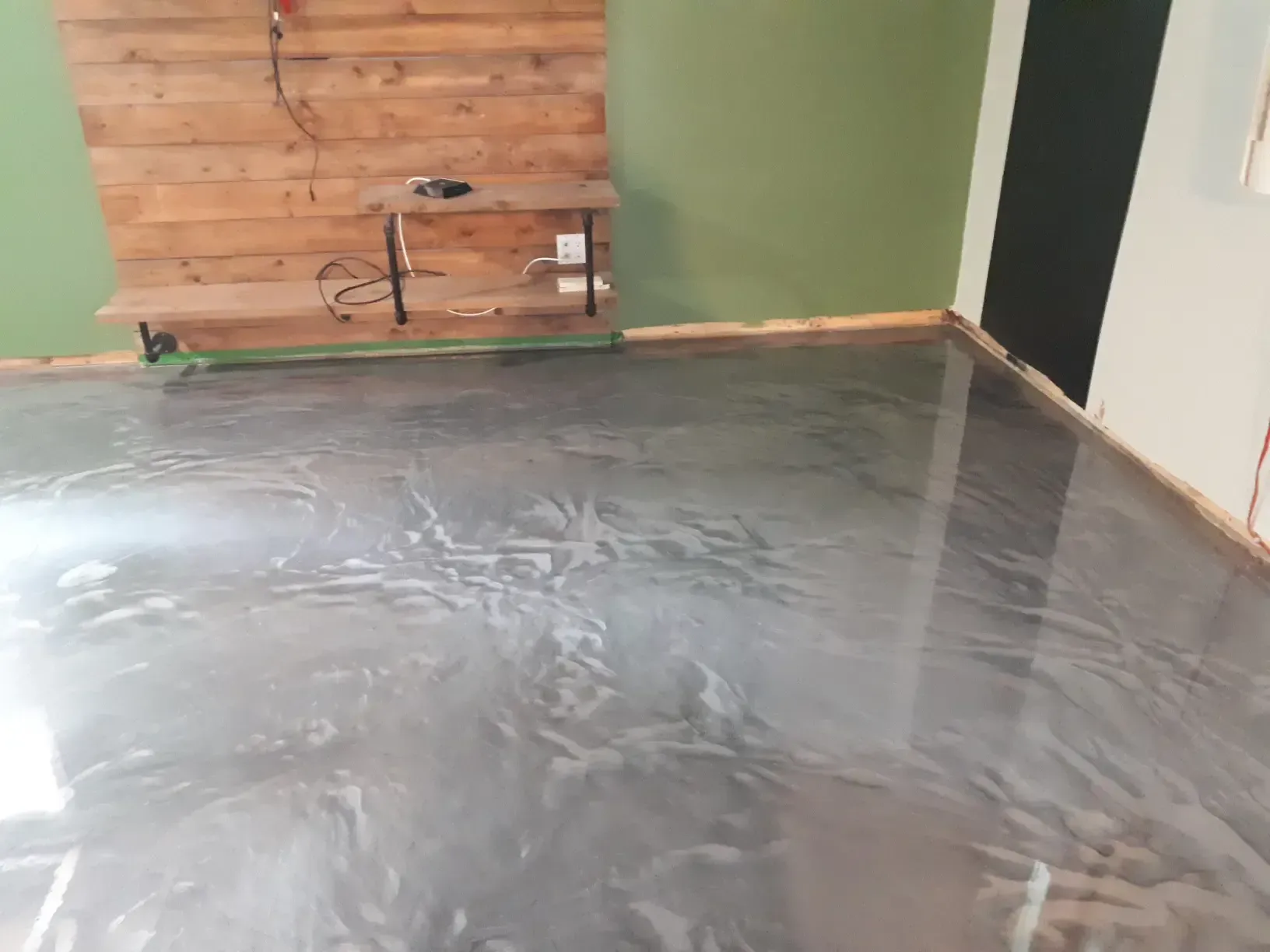 A living room with a metallic floor and a wooden wall.