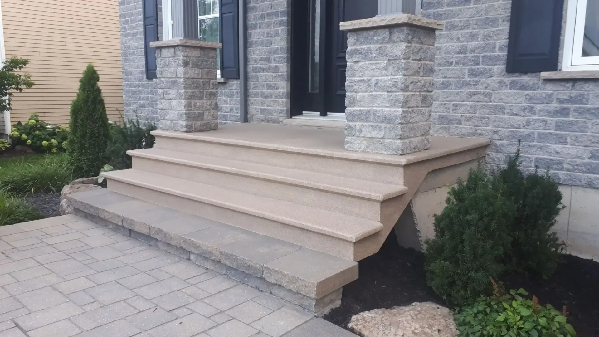 A brick house with stairs leading up to the front door