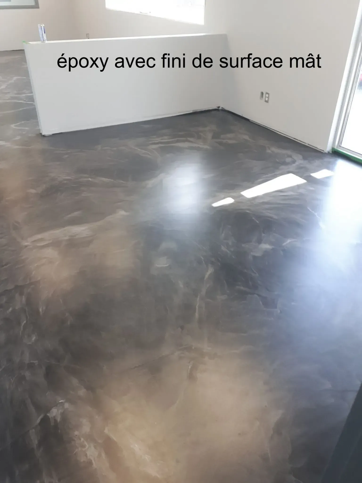 A room with a concrete floor and a white wall.