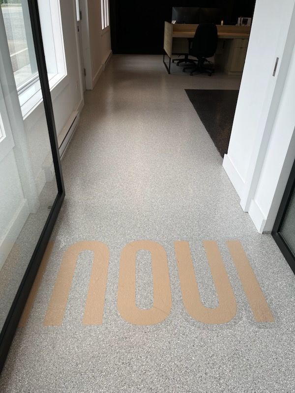 Hallway with speckled floor; the word 