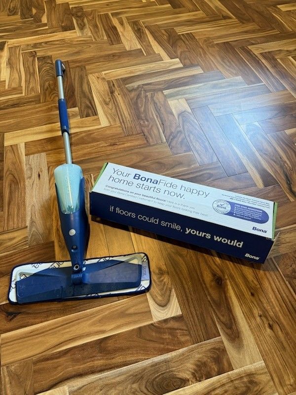 Close-up of a recently cleaned or polished wood floor laid in a chevron or herringbone pattern.