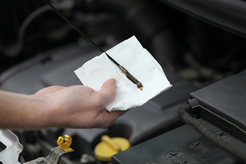 An ad of a  person is checking the oil level of a car featuring Auto deals online