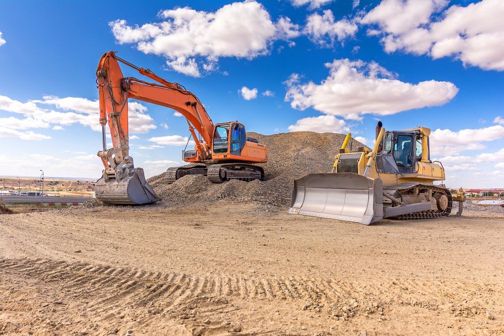 Orange Excavator and Yellow Bulldozer on a Dirt Construction Site — Waite Diesel Service in Douglas, QLD